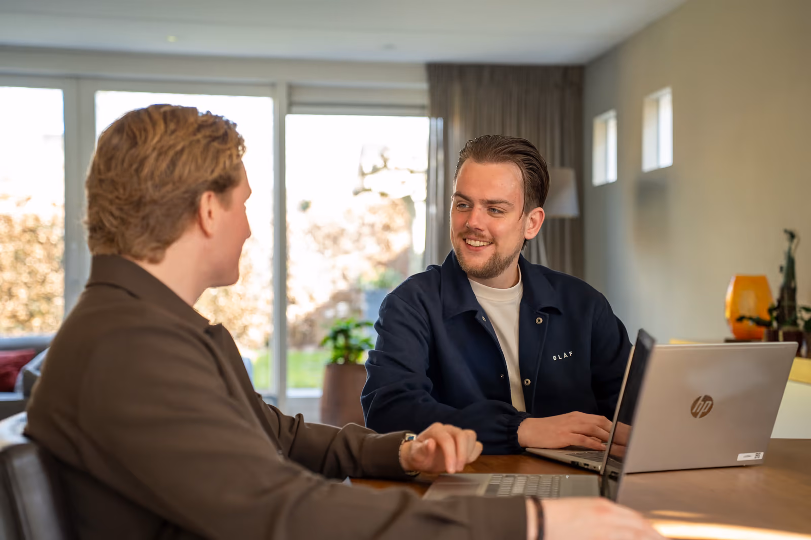 Stan en Timo lachend in overleg aan tafel