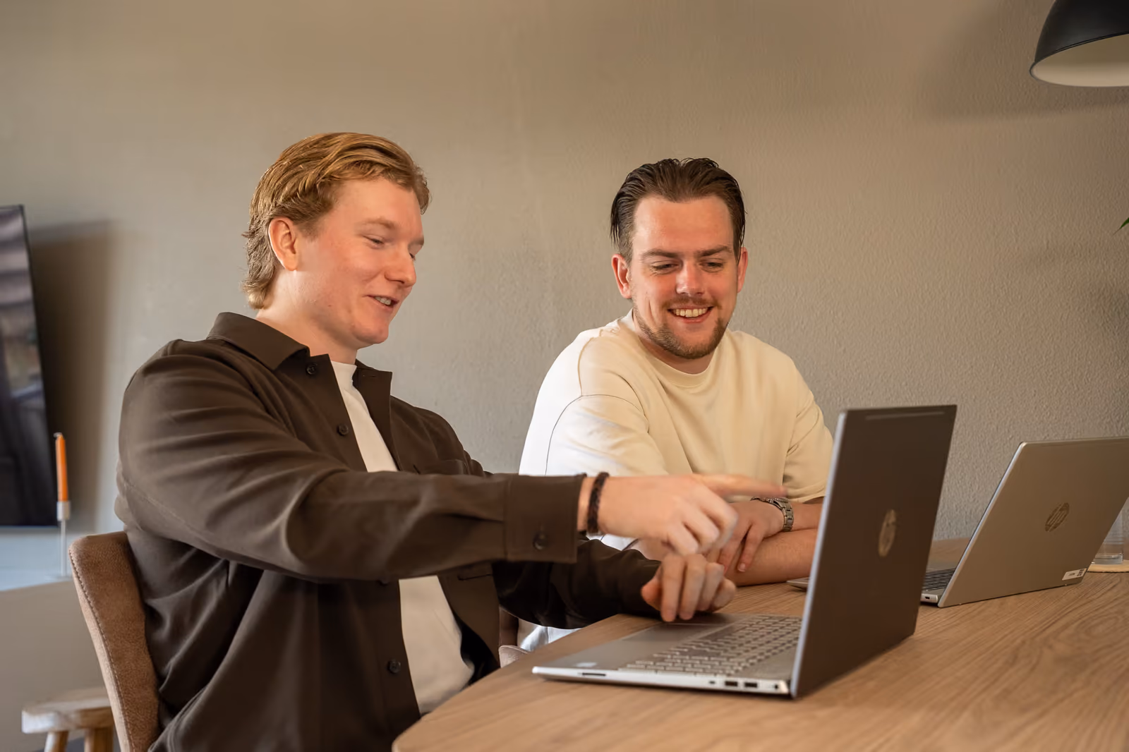 Stan en Timo bekijken samen de resultaten op de laptop
